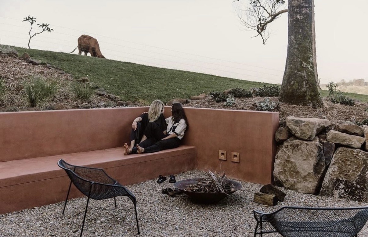 A couple beside the fire pit at The Perch at dusk